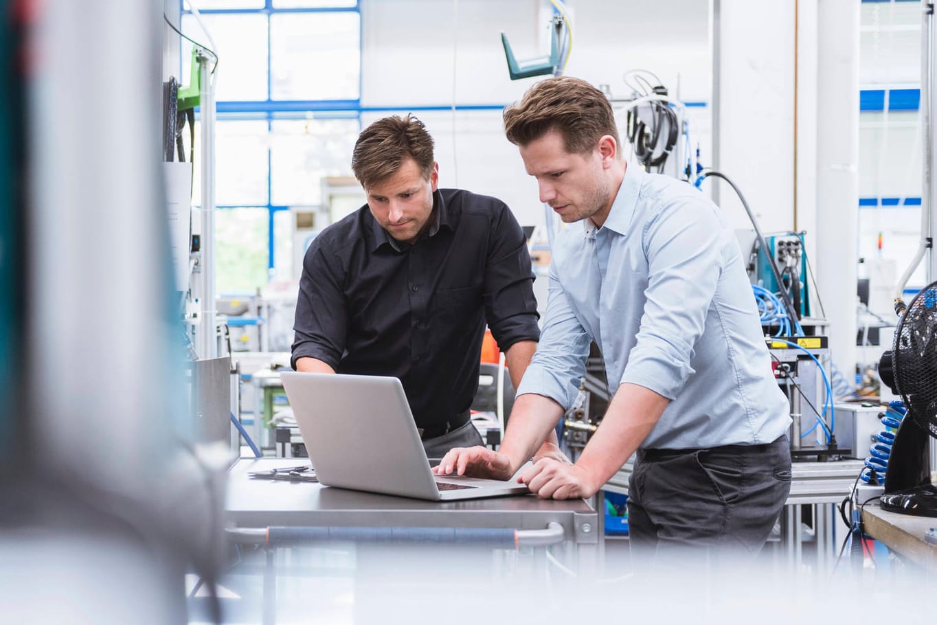 Zwei Männer an einem Computer in einem Unternehmen: Rund die Hälfte der deutschen Unternehmen hat Cyber-Angriffe erlitten