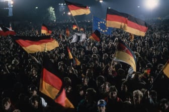 Menschen feiern die Deutsche Wiedervereinigung am 3. Oktober 1990