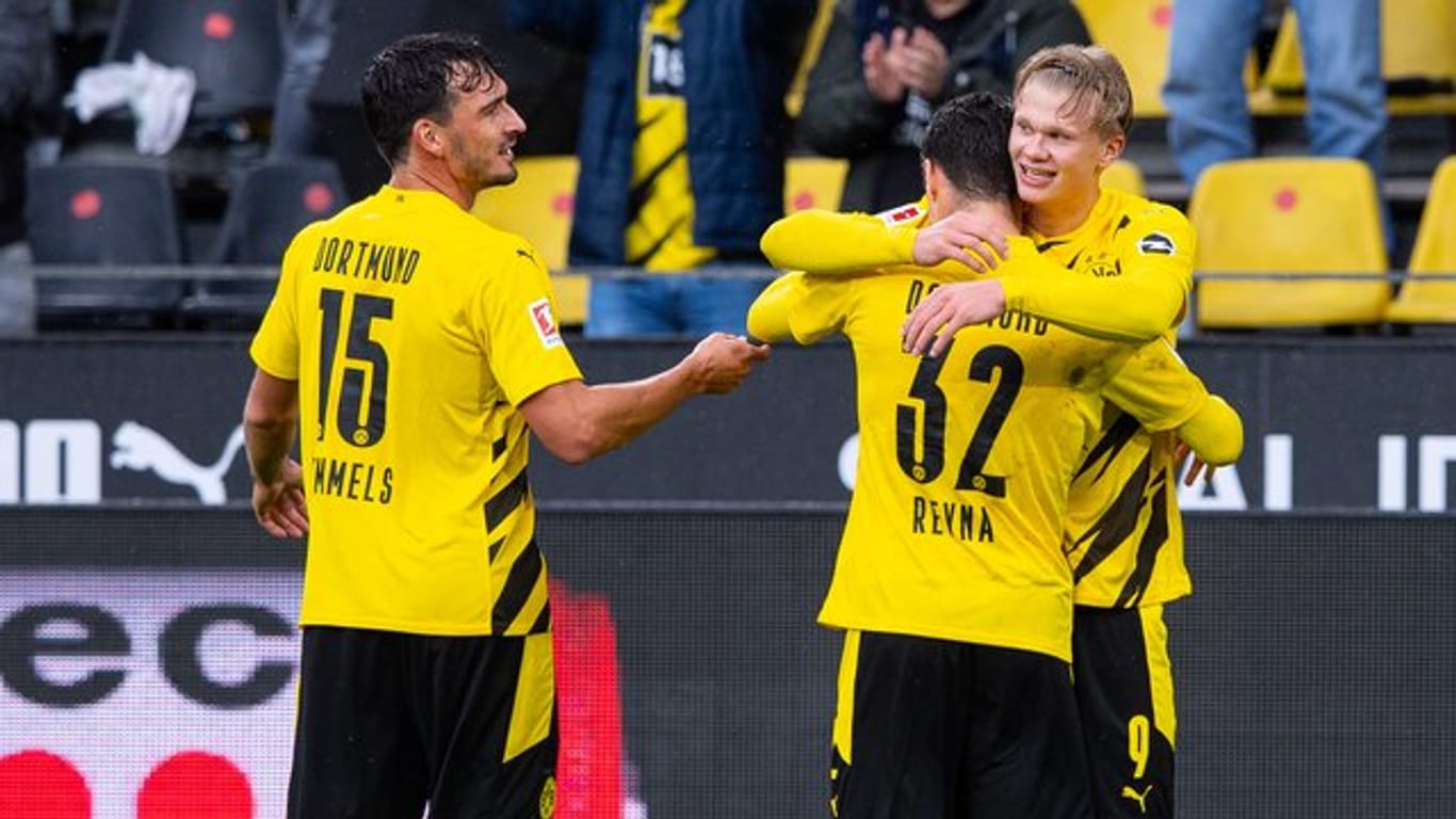 Mats Hummels (l) feiert mit dem Giovanni Reyna (32) umarmenden Erling Haaland einen Treffer im Spiel gegen den SC Freiburg.