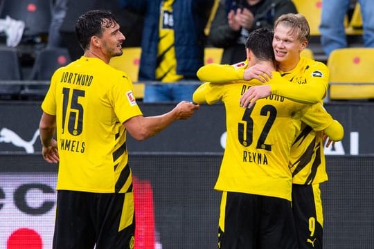 Mats Hummels (l) feiert mit dem Giovanni Reyna (32) umarmenden Erling Haaland einen Treffer im Spiel gegen den SC Freiburg.