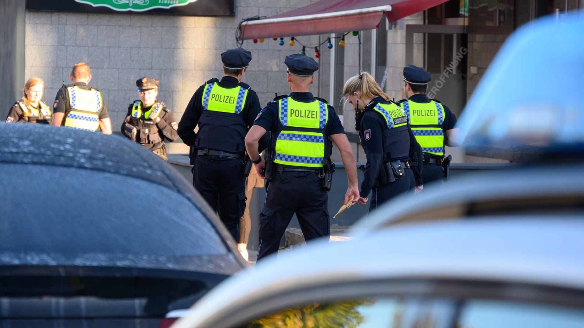 Polizisten stehen auf dem Gehweg und besprechen sich: Ein Mann ist bei einem Streit verletzt worden. Polizisten stehen auf dem Gehweg und besprechen sich: Ein Mann ist bei einem Streit verletzt worden.