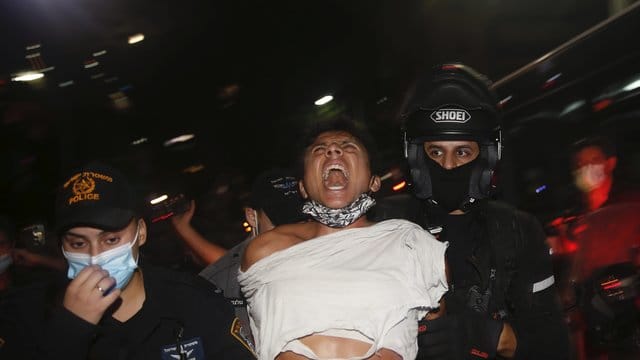 Israelische Polizeibeamte verhaften einen Demonstranten bei einem Protest gegen Sperrmaßnahmen, die ihrer Meinung nach darauf abzielen, die Proteste gegen Israels Premierminister Netanjahu einzudämmen. Israelische Polizeibeamte verhaften einen Demonstranten bei einem Protest gegen Sperrmaßnahmen, die ihrer Meinung nach darauf abzielen, die Proteste gegen Israels Premierminister Netanjahu einzudämmen.