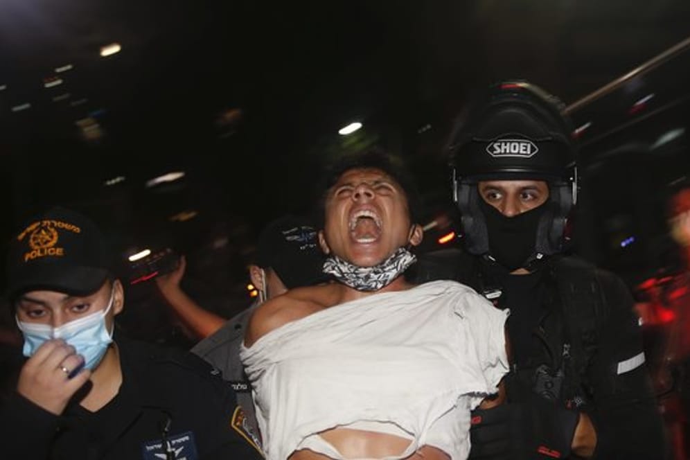 Israelische Polizeibeamte verhaften einen Demonstranten bei einem Protest gegen Sperrmaßnahmen, die ihrer Meinung nach darauf abzielen, die Proteste gegen Israels Premierminister Netanjahu einzudämmen.