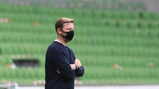 Werders Trainer Florian Kohfeldt steht mit Mund-Nase-Schutz am Spielfeldrand. Werders Trainer Florian Kohfeldt steht mit Mund-Nase-Schutz am Spielfeldrand.