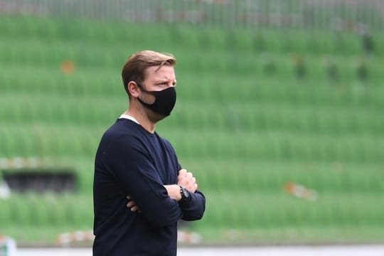Werders Trainer Florian Kohfeldt steht mit Mund-Nase-Schutz am Spielfeldrand.