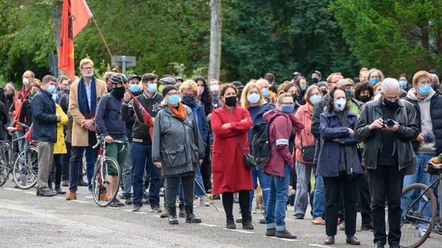 Teilnehmer einer Mahnwache stehen auf der Straße vor der Hamburger Synagoge.