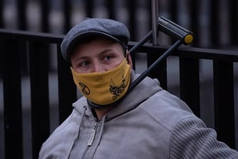 Ein Umweltaktivist von Extinction Rebellion (XR) hat sich mit einem Bügelschloss an einem Gitter am Bundesverkehrsministerium angeschlossen.