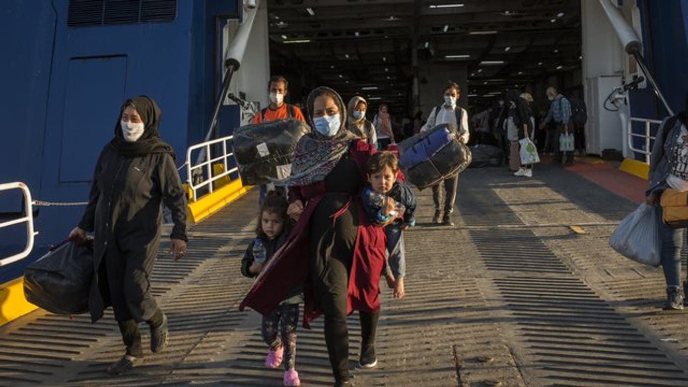 Flüchtlinge aus dem kürzlich ausgebrannten Lager Moria auf Lesbos und anderen griechischen Inseln verlassen eine Fähre im Hafen von Lavrio bei Athen.