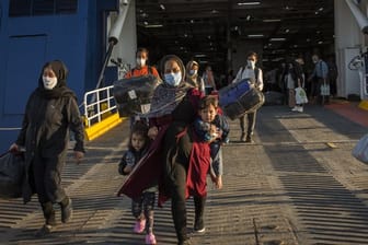 Flüchtlinge aus dem kürzlich ausgebrannten Lager Moria auf Lesbos und anderen griechischen Inseln verlassen eine Fähre im Hafen von Lavrio bei Athen.