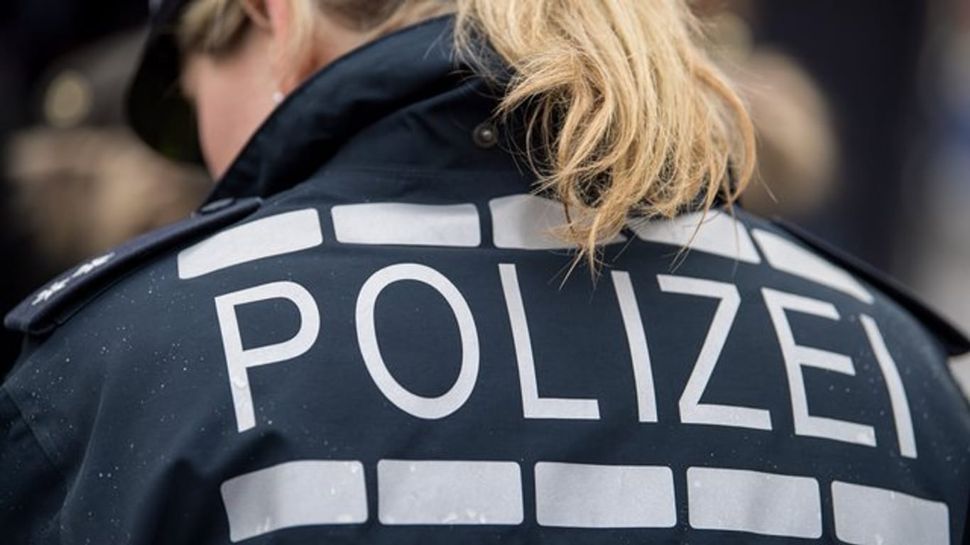 Der Pferdeschwanz einer Polizisten fällt auf ihre Jacke: Beamte haben in Frankfurt vier Männer festgenommen.