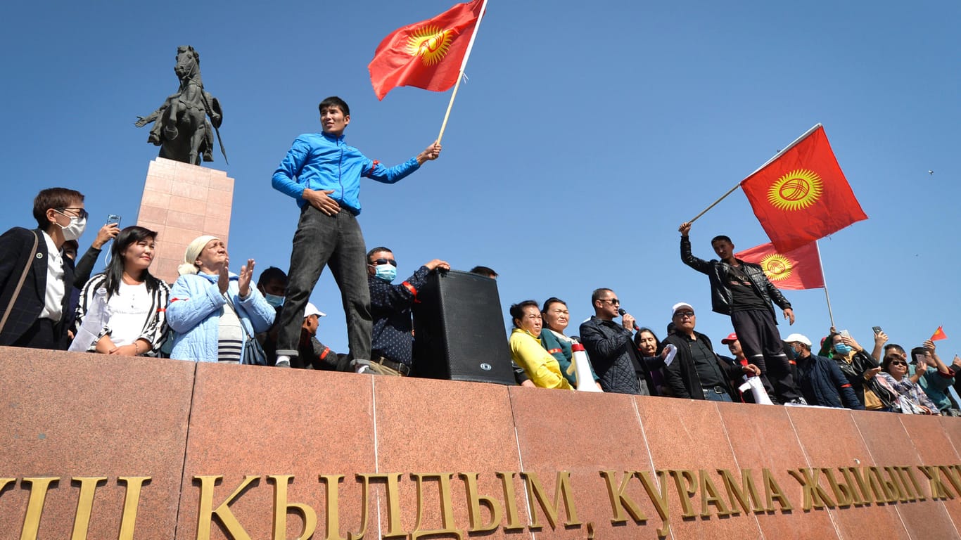 Menschen protestieren während einer Kundgebung gegen die Ergebnisse einer Parlamentsabstimmung. Nach der Parlamentswahl in Kirgistan ist es zu Ausschreitungen gekommen.