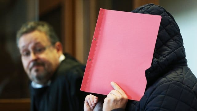 Der Angeklagte im Prozess wegen schweren sexuellen Missbrauchs hält sich im Gerichtssaal eine Mappe vor das Gesicht. Der Angeklagte im Prozess wegen schweren sexuellen Missbrauchs hält sich im Gerichtssaal eine Mappe vor das Gesicht.