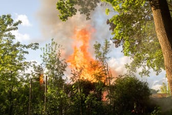 Eine Gartenlaube steht in Flammen (Symbolbild): In Hagen-Hohenlimburg ist eine Gartenlaube komplett ausgebrannt.