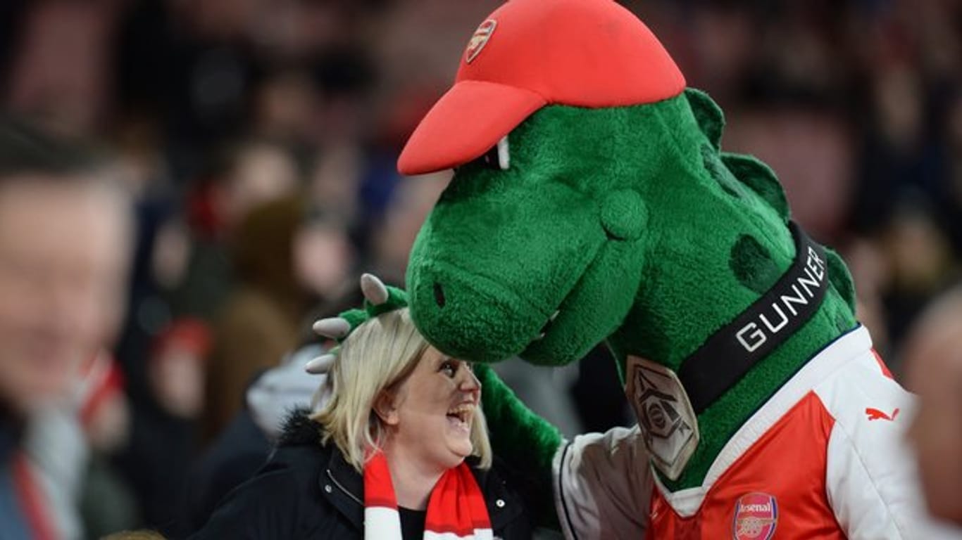Bei den Fans beliebt Arsenal-Maskottchen "Gunnersaurus" umarmt vor Spielbeginn eine Frau.
