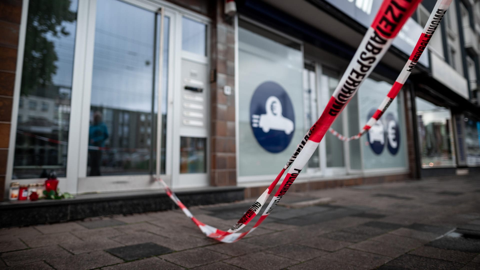 Duisburg: Der Eingang des Hauses ist mit Flatterband der Polizei abgesperrt, Rosen und Kerzen wurden neben die Haustüre gelegt. Duisburg: Der Eingang des Hauses ist mit Flatterband der Polizei abgesperrt, Rosen und Kerzen wurden neben die Haustüre gelegt.