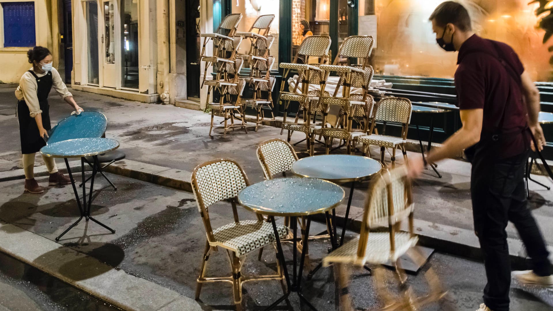 Mitarbeiter eines Cafés mit Mundschutz räumen am Abend Stühle und Tische auf (Symbolbild): Frankfurt liegt noch knapp unter dem kritischen Warnwert für das Corona-Infektionsgeschehen. Mitarbeiter eines Cafés mit Mundschutz räumen am Abend Stühle und Tische auf (Symbolbild): Frankfurt liegt noch knapp unter dem kritischen Warnwert für das Corona-Infektionsgeschehen.