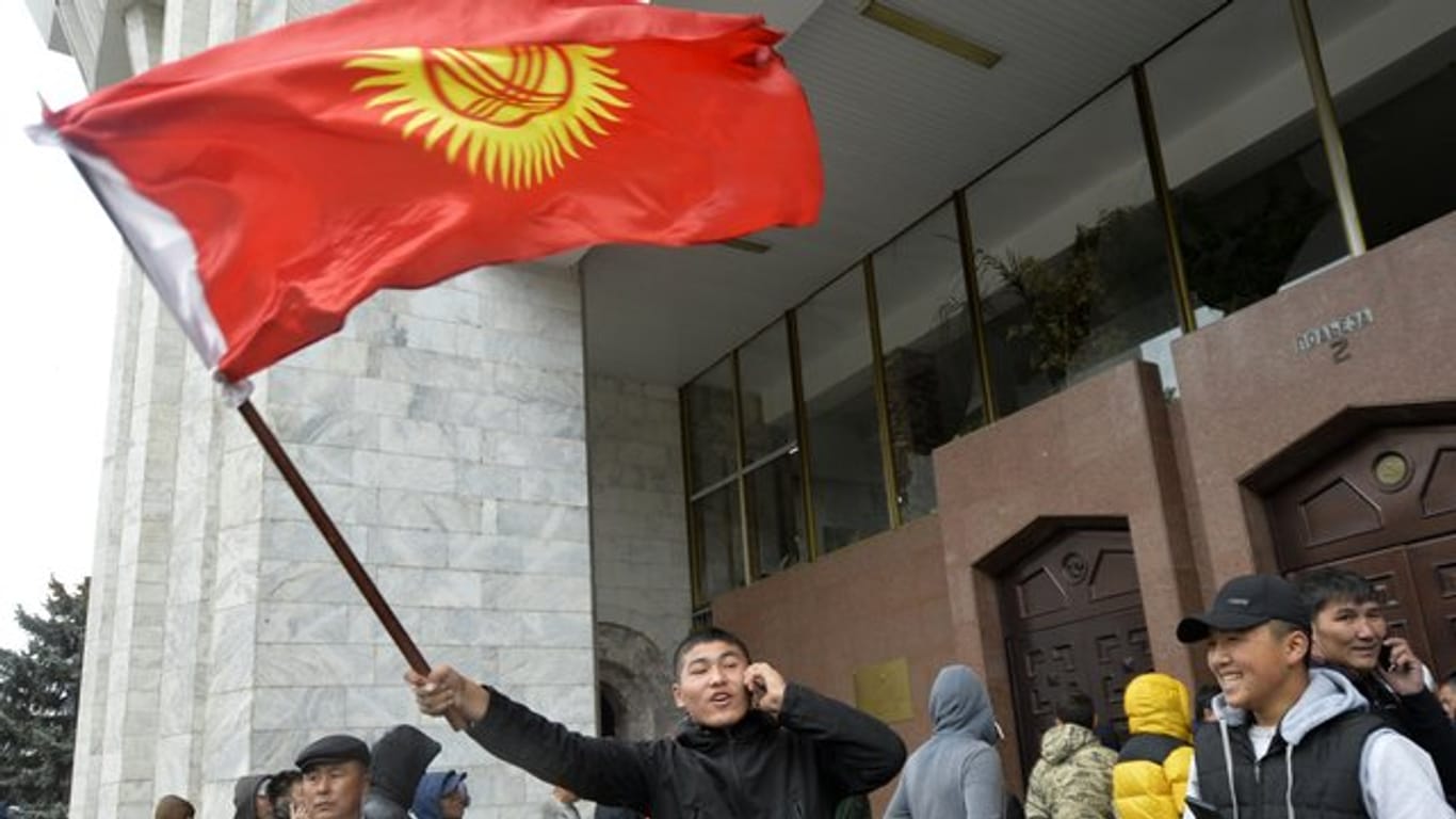 Demonstranten stehen vor dem Regierungsgebäude in Bischtek.