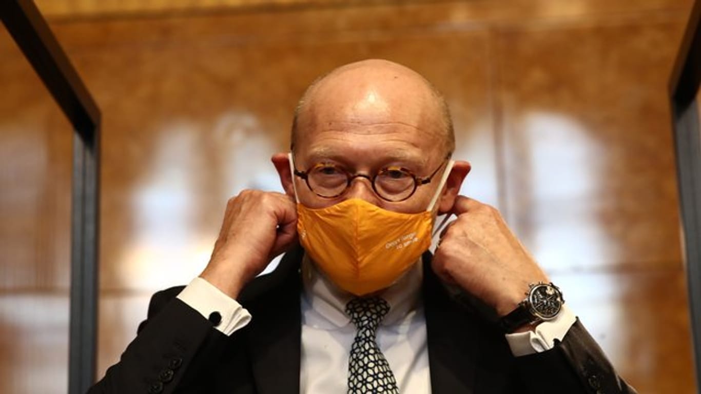 Michael Westhagemann, Wirtschaftssenator von Hamburg, zieht sich einen Mund-Nasen-Schutz an (Archivbild): Hamburg hat einen Mechanismus für schärfere Corona-Maßnahmen beschlossen.