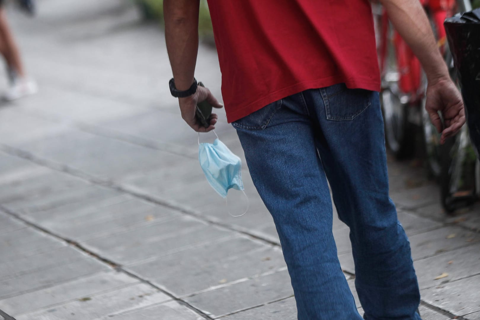 Ein Mann hält einen Mund-Nasen-Schutz in der Hand (Symbolbild): Hagen hat den kritischen Wert von 50 Neuinfektionen pro 100.000 Einwohner auf sieben Tage überschritten.