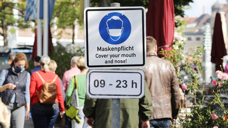 Hinweisschild am Viktualienmarkt: Auf diesem und anderen zentralen Plätzen Münchens gilt tagsüber und abends eine Maskenpflicht.