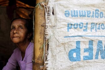 Eine ältere Frau schaut aus einem Zelt imi einem Flüchtlingslager in Myanmar.