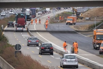 Bauarbeiter stehen in einer Baustelle auf der Autobahn A7