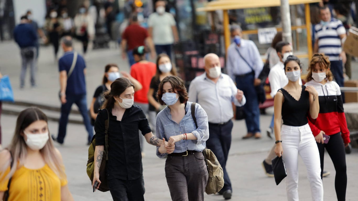 Menschen auf der Straße tragen Mund-Nasen-Schutz (Symbolbild): Die Corona-Fallzahlen in Essen liegen knapp unter dem kritischen Warnwert.