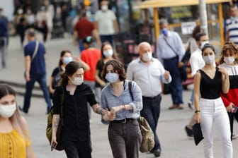Menschen auf der Straße tragen Mund-Nasen-Schutz (Symbolbild): Die Corona-Fallzahlen in Essen liegen knapp unter dem kritischen Warnwert.