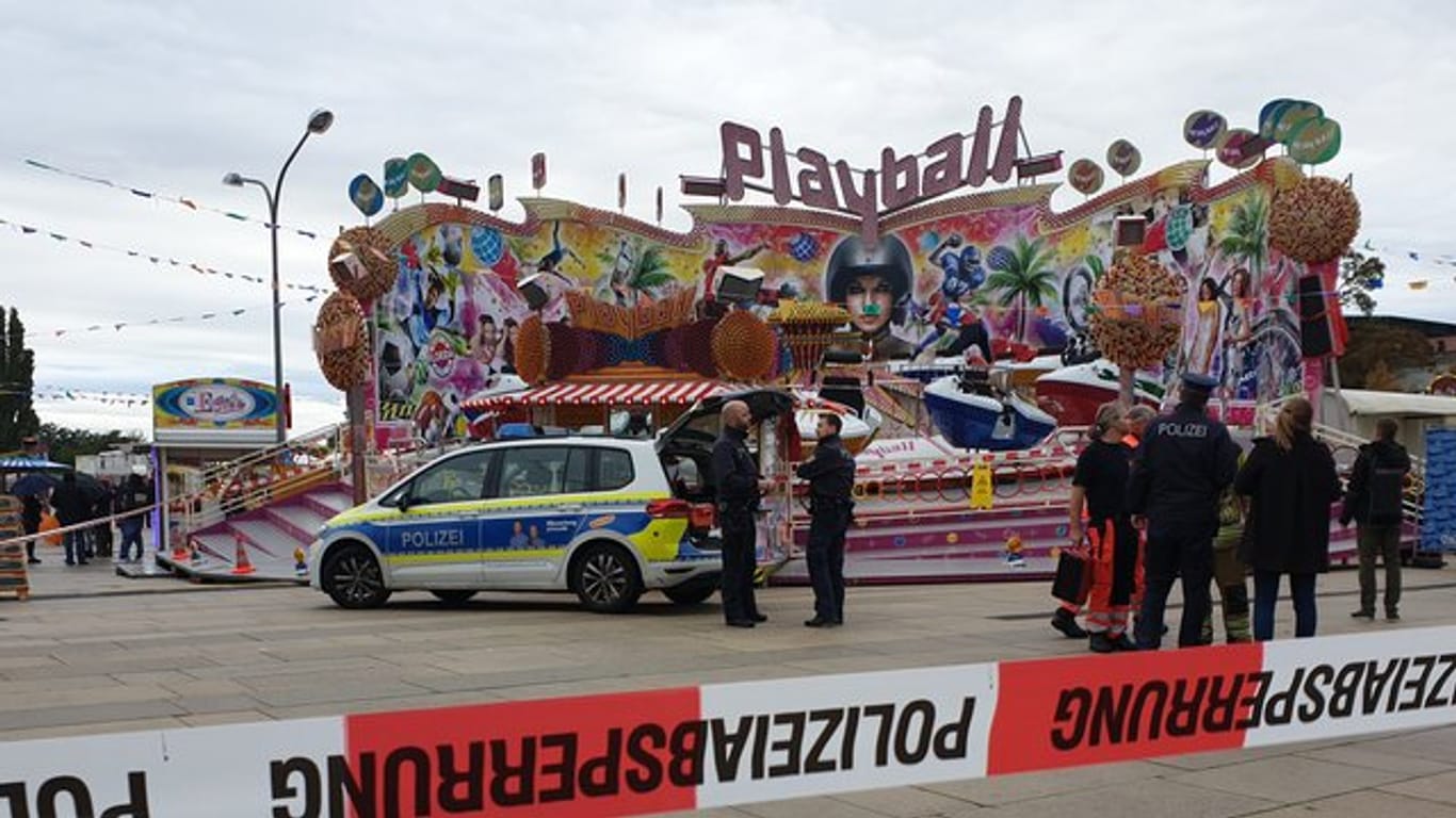 Polizisten und ein Polizeiwagen stehen vor dem Fahrgeschäft "Playball" beim "Potsdamer Oktoberfest".