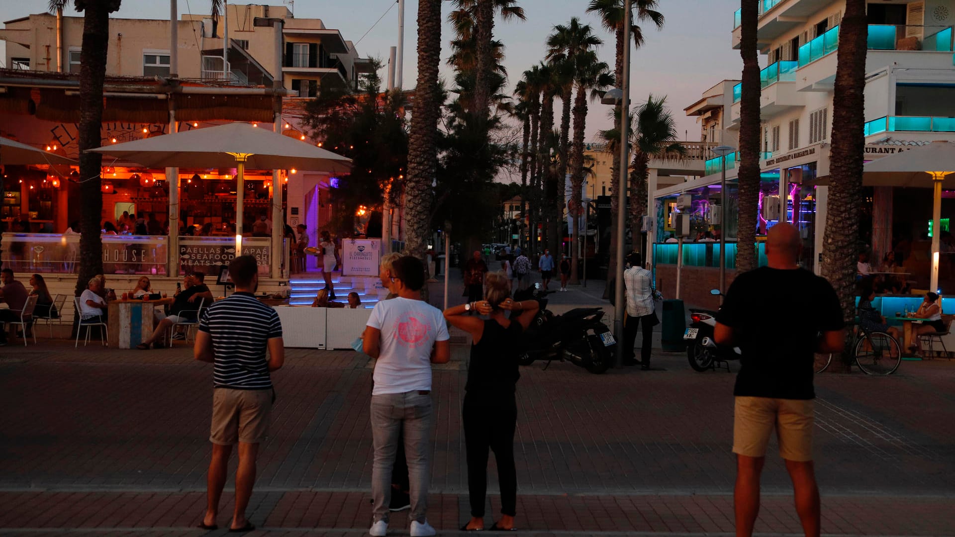 Touristen stehen in der Nähe der "Bierstraße" am Strand von Arenal: Lokale am "Ballermann" dürfen bald wieder Gäste empfangen.