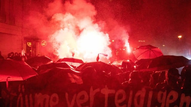 Demonstranten zünden bei einer Demonstration Bengalische Feuer. Demonstranten zünden bei einer Demonstration Bengalische Feuer.