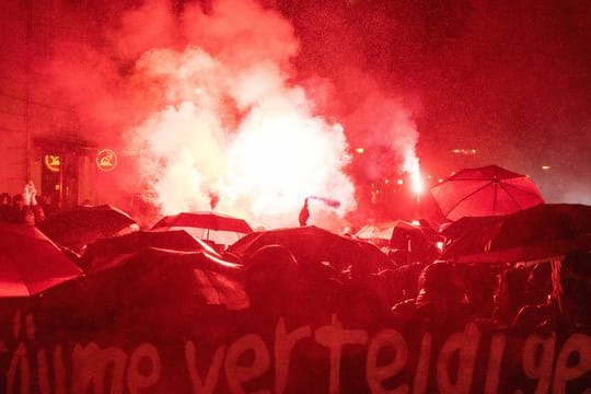 Demonstranten zünden bei einer Demonstration Bengalische Feuer.