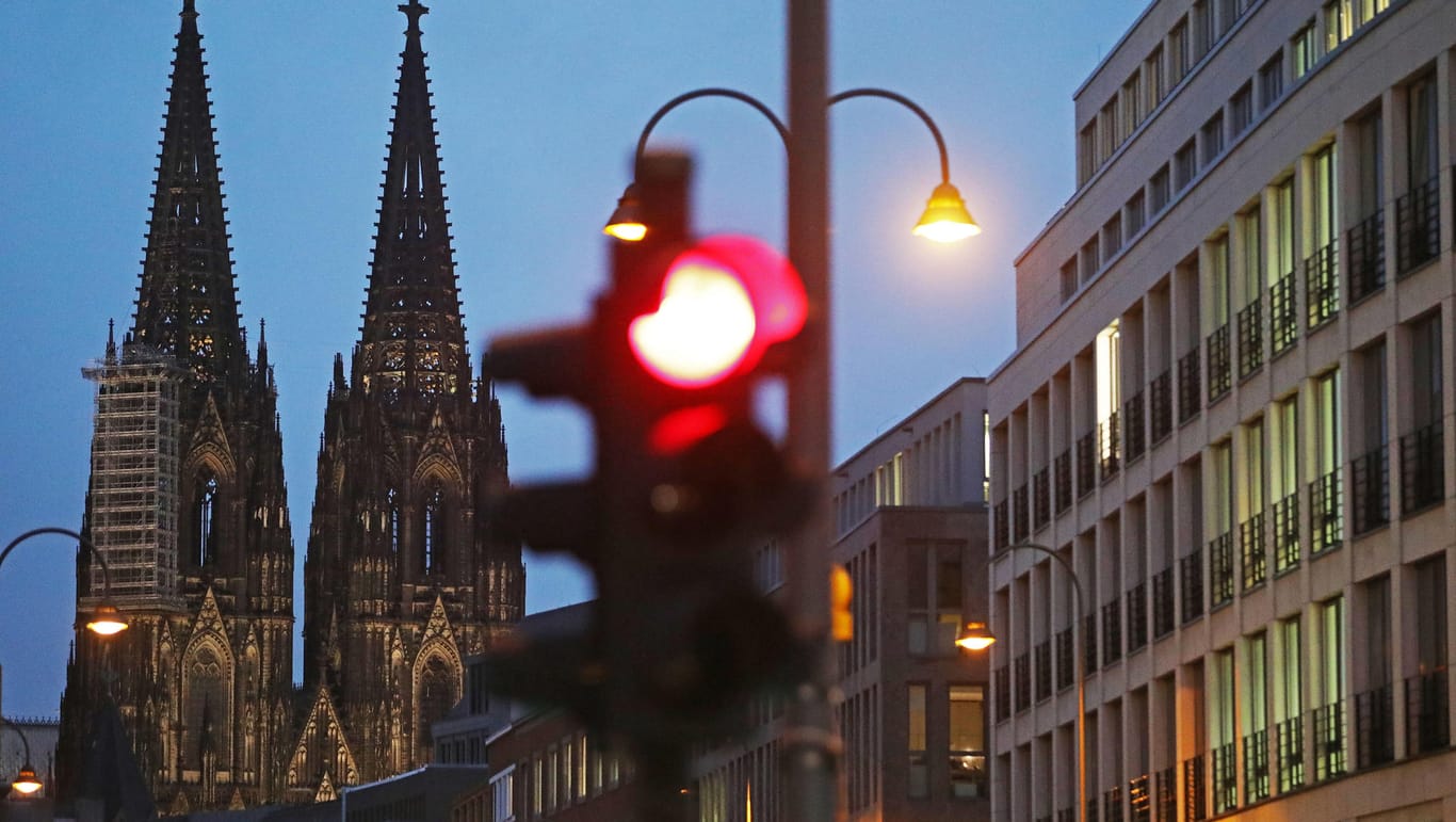 Eine Ampel steht am Dom auf Rot: Köln hat die wichtige Warnstufe von 50 Neuinfektionen pro 100.000 Einwohner in sieben Tagen überschritten.