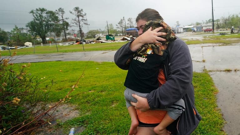 Eine Frau flüchtet mit ihrem Kind vor dem schweren Sturm "Delta".