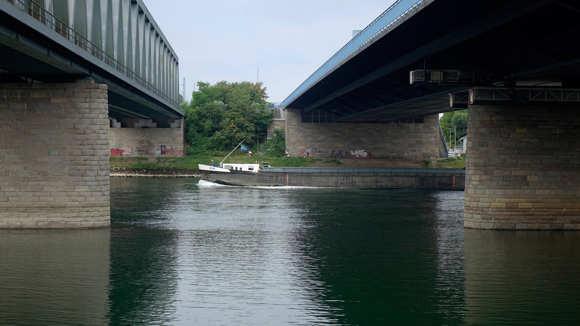 Transportschiff unter den Rheinbrücken (Archivbild): Auf dem Rhein bei Karlsruhe hat es einen Schiffsunfall gegeben.