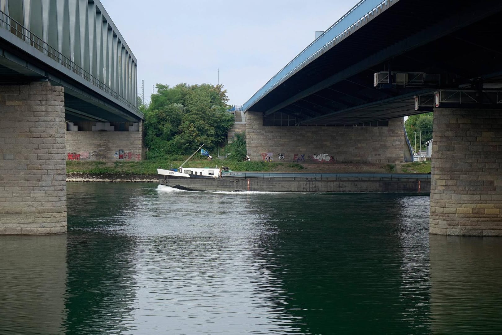 Transportschiff unter den Rheinbrücken (Archivbild): Auf dem Rhein bei Karlsruhe hat es einen Schiffsunfall gegeben.