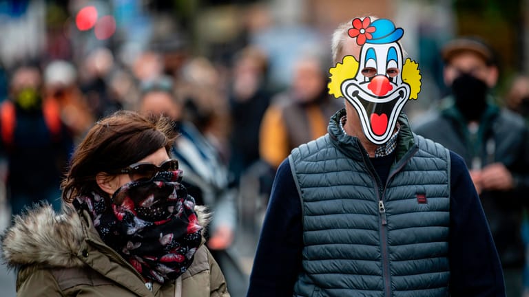Ein Teilnehmer der Corona-Demonstration in Berlin läuft mit einer Clowns-Maske aus Papier durch die Innenstadt: Die Veranstalter der Demo haben zu einem Schweigemarsch aufgerufen.