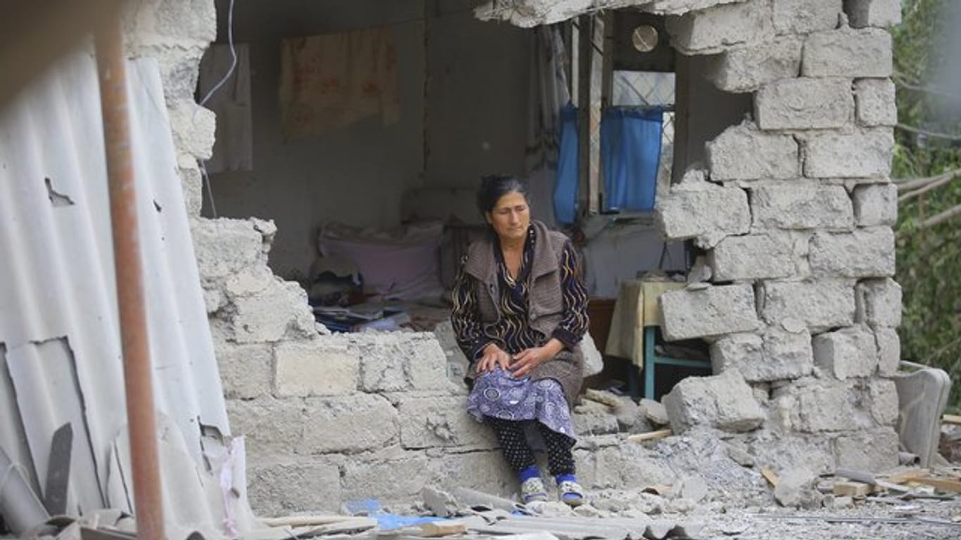 Eine Frau sitzt nach einem Beschuss der armenischen Artillerie inmitten der Trümmer ihres Hauses.