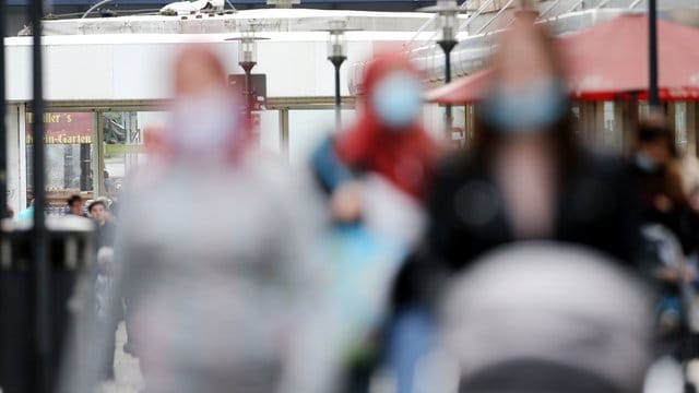 Passanten mit und ohne Mund-Nasen-Schutz gehen durch eine Einkaufsstraße in Essen. Passanten mit und ohne Mund-Nasen-Schutz gehen durch eine Einkaufsstraße in Essen.