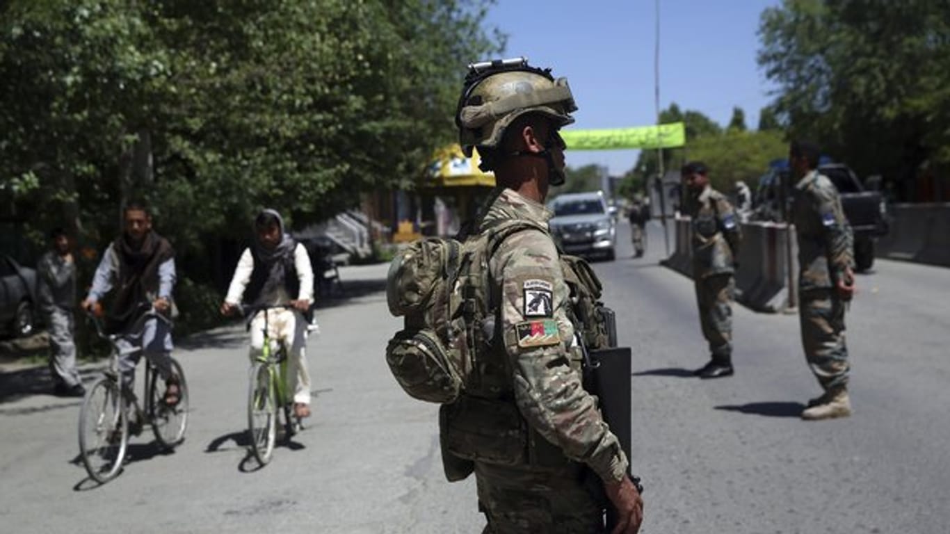 Ein afghanischer Soldat steht auf einer Straße Wache.