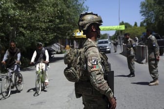 Ein afghanischer Soldat steht auf einer Straße Wache.