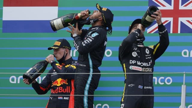 Auf dem Podest genehmigen sich der Zweitplatzierte Max Verstappen (l-r), Sieger Lewis Hamilton und Daniel Ricciardo zunächst einen großen Schluck. Auf dem Podest genehmigen sich der Zweitplatzierte Max Verstappen (l-r), Sieger Lewis Hamilton und Daniel Ricciardo zunächst einen großen Schluck.
