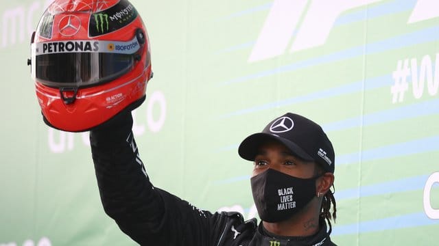 Lewis Hamilton feiert mit dem Helm von Michael Schumacher den Sieg auf dem Nürburgring.