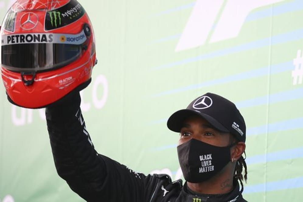 Lewis Hamilton feiert mit dem Helm von Michael Schumacher den Sieg auf dem Nürburgring.
