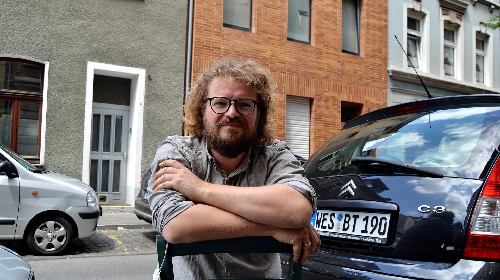 Landwirt Groß sitzt auf einem Stuhl vor dem Laden im Kölner Stadtteil Ehrenfeld.