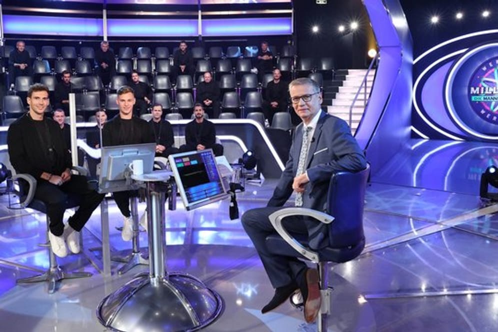 Moderator Günther Jauch (r) sitzt mit Spielern des DFB-Teams im Studio der Quiz-Show "Wer wird Millionär?".