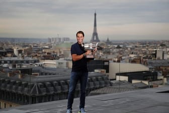 French-Open-Sieger Rafael Nadal posiert mit dem Siegerpokal vor der Kulisse von Paris auf dem Dach der Galeries Lafayette.