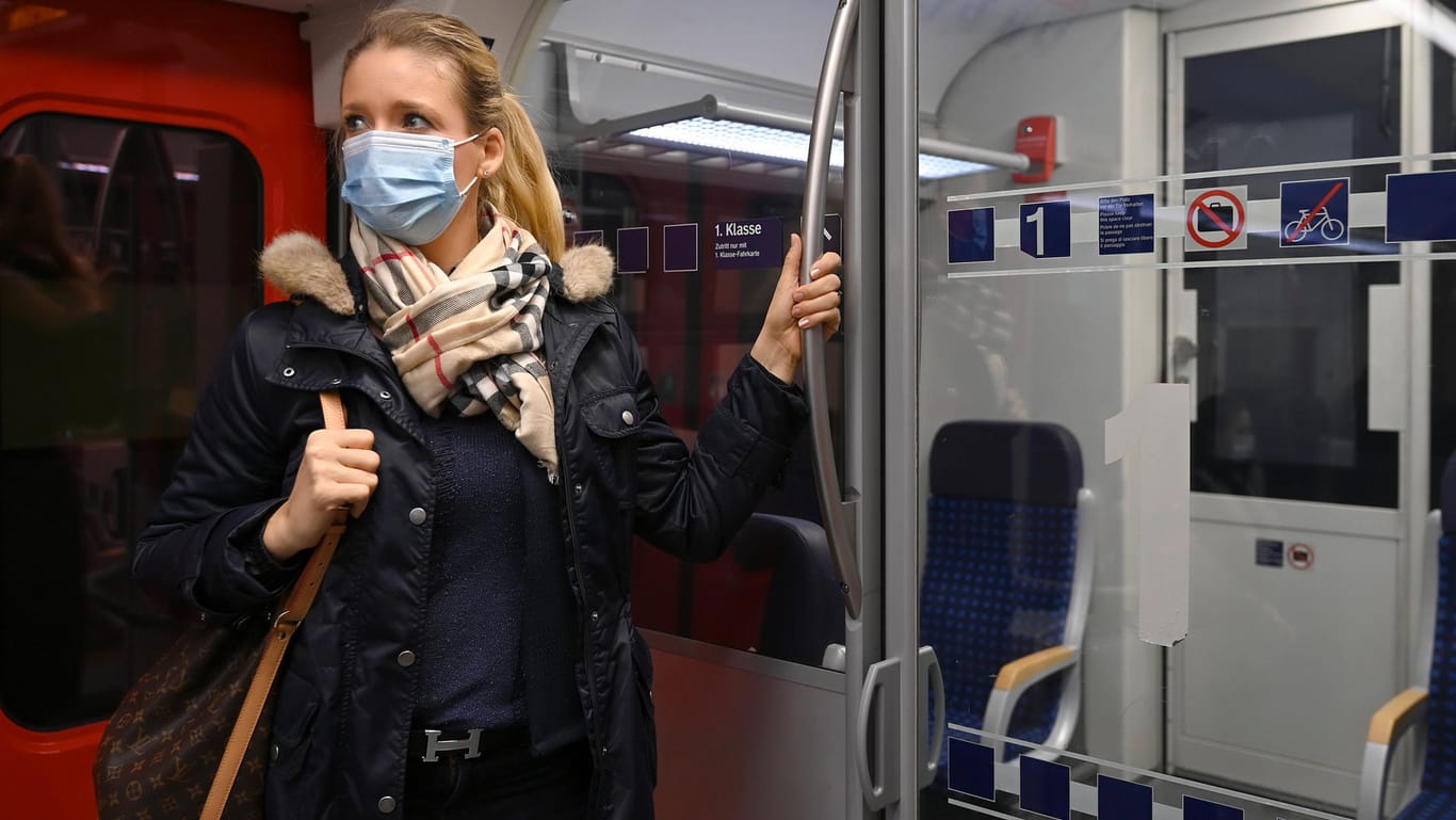 Frau steht mit Maske im Zug: Eine Umfrage zeigt, dass eine Mehrheit sich dafür ausspricht, Maskenverweigerer hart zu bestrafen.