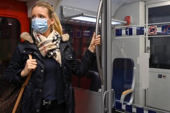 Frau steht mit Maske im Zug: Eine Umfrage zeigt, dass eine Mehrheit sich dafür ausspricht, Maskenverweigerer hart zu bestrafen.