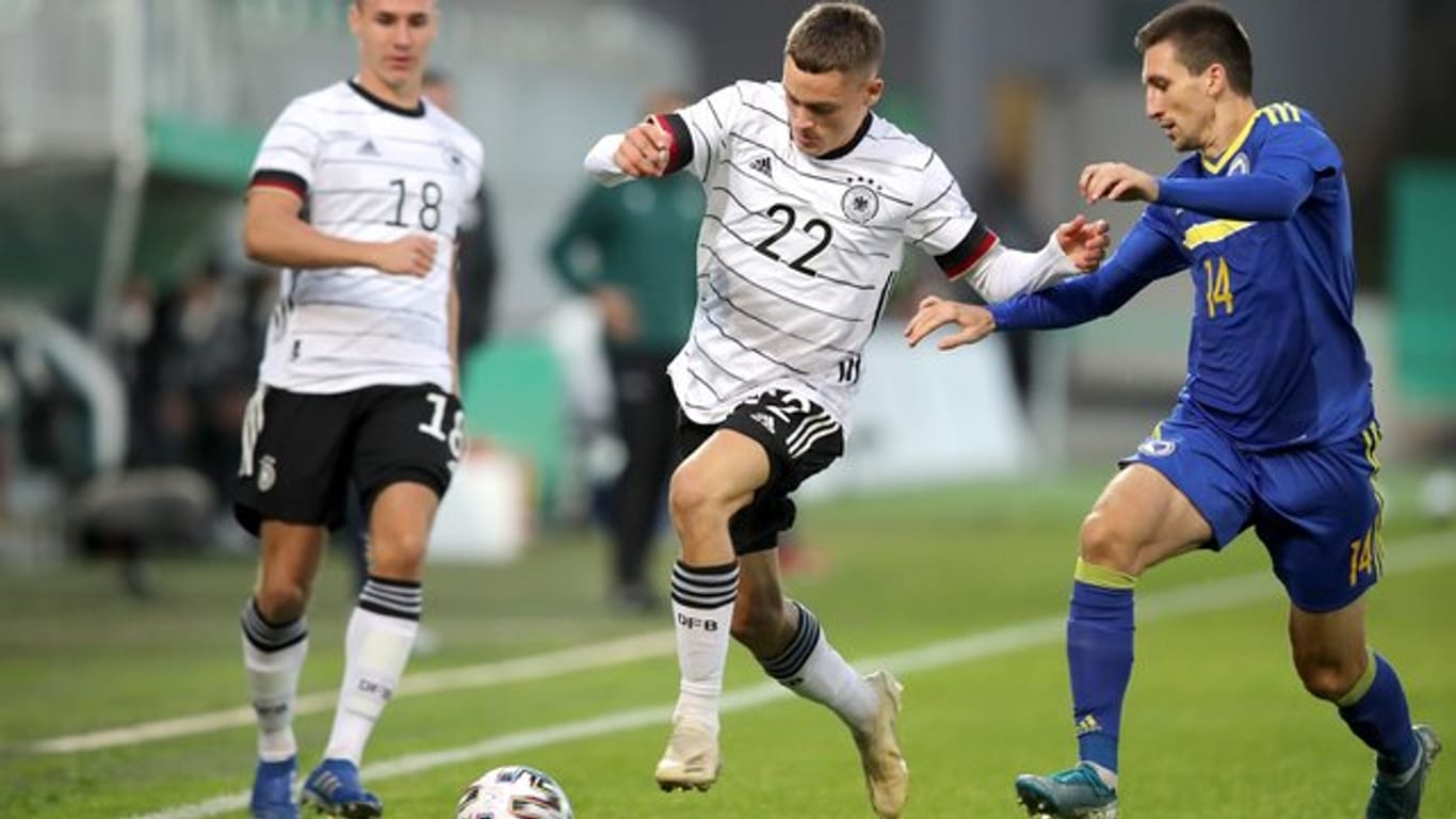 Florian Wirtz (M) kämpft mit Mateo Maric (r) aus Bosnien-Herzegowina um den Ball.